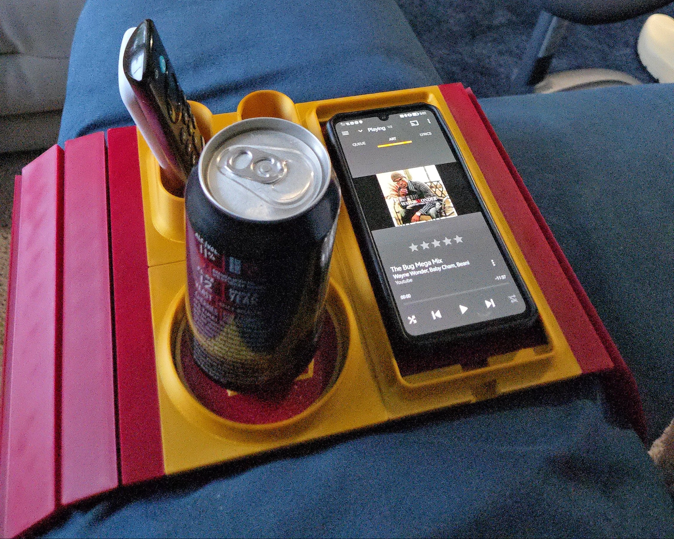 Couch Organizerwith a smartphone, can, and bottle on a colorful tray in a living room