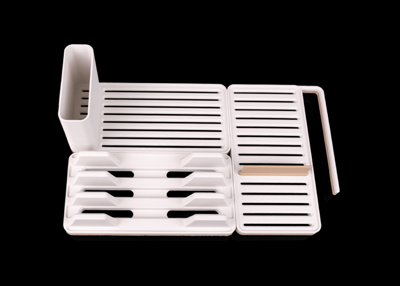White dish drying rack with cutlery holder on a black background