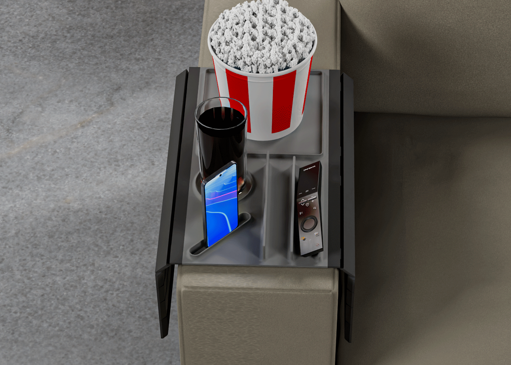 Popcorn bucket, phone, and remote control on a small table next to a couch.
