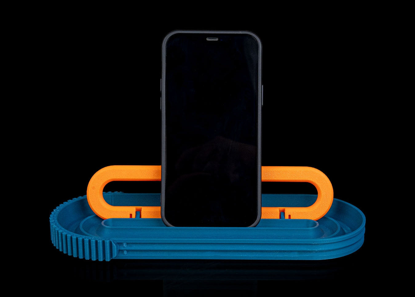 Phone on a blue and orange stand against a black background