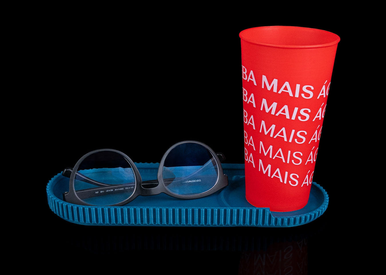Red cup with text on a blue tray against a black background